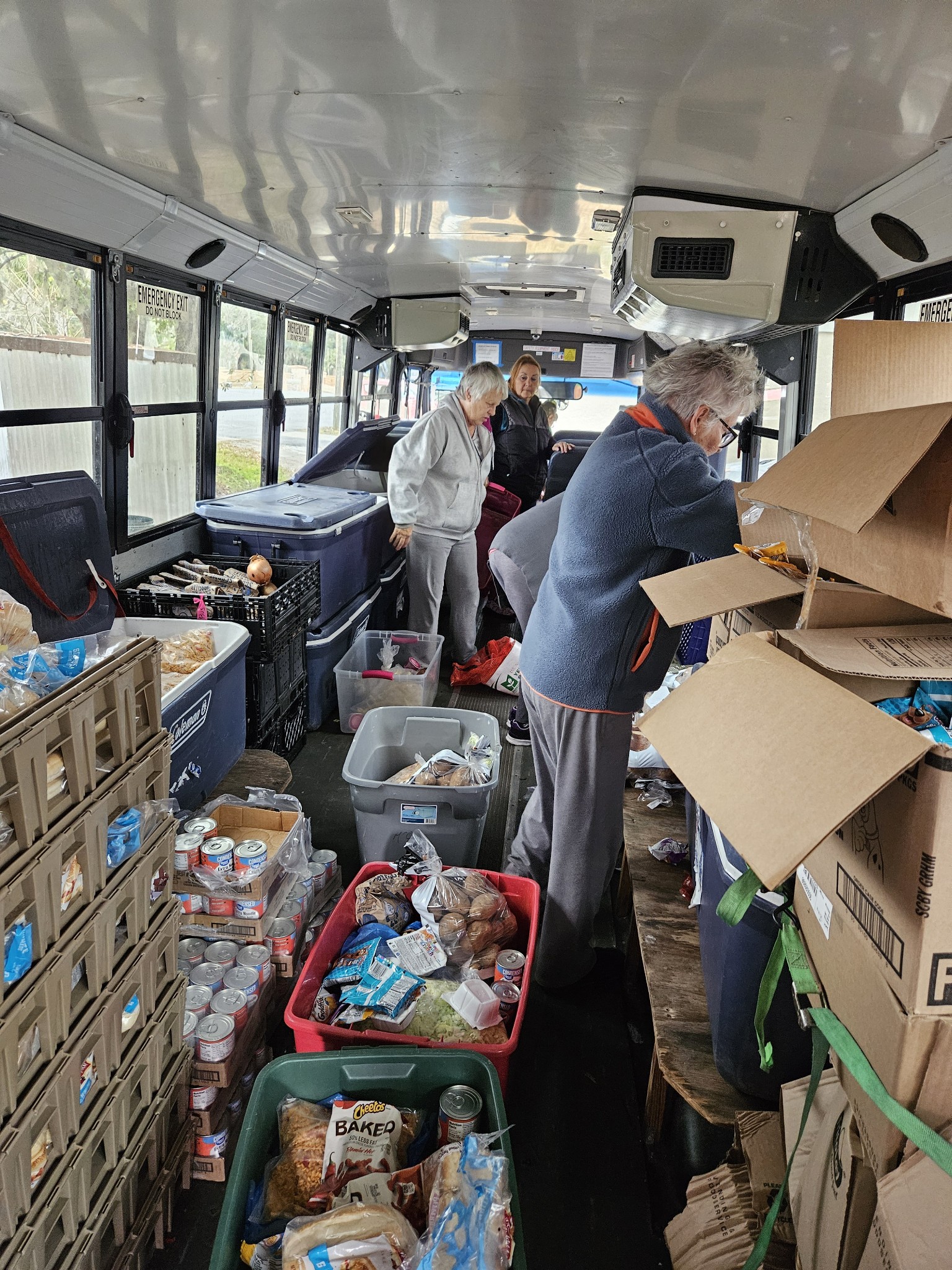 Personas organizando alimentos dentro del autobús de distribución de The Children’s Table